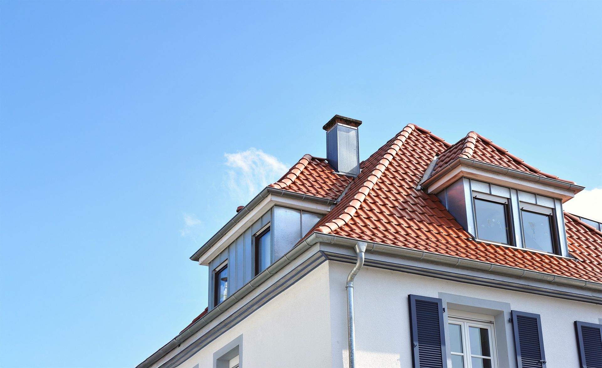 Dachsanierung Einfamilienhaus mit roten Tondachziegeln, Gauben und Zinkblechverkleidung vom Dachdecker